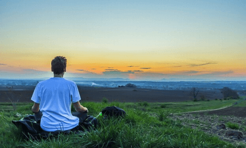 homem meditando ao amanhecer