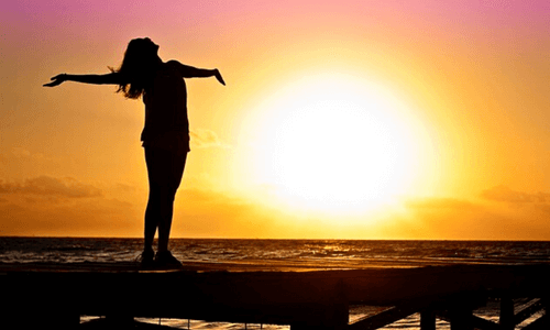 mulher feliz no por do sol