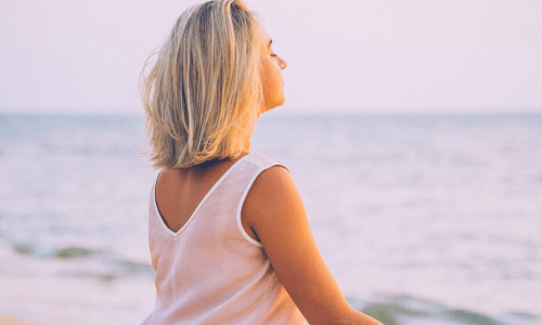 mulher meditando na praia