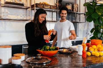 mulher e homem cozinhando saudável